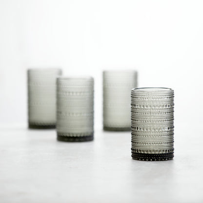 4 smoke grey jupiter iced beverage glasses arranged on a countertop.