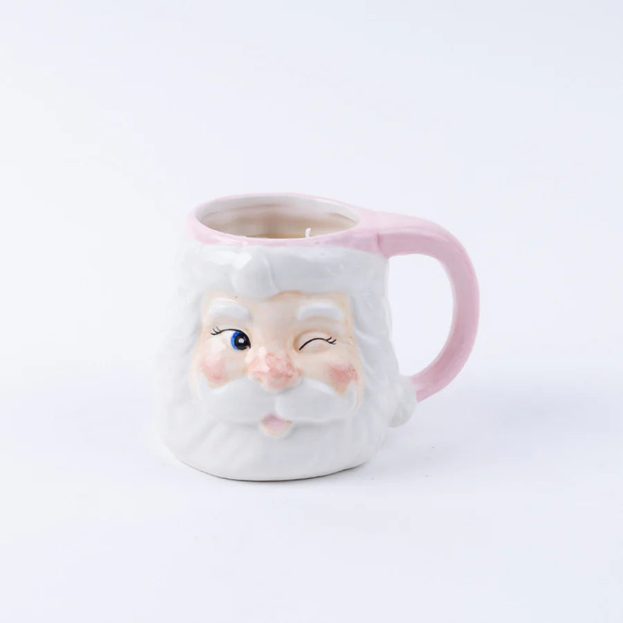 pink and white santa face mug filled with a candle
