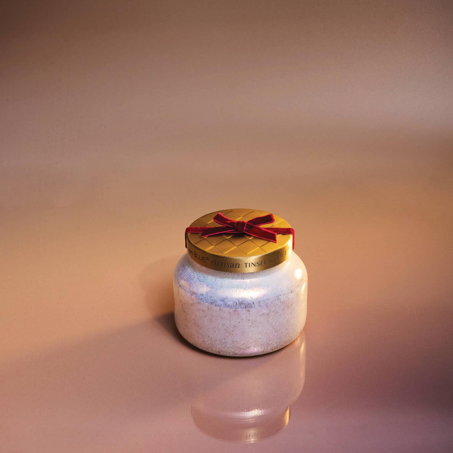 Cinnamon Cortado Artisan Winter Bazaar Signature Candle on a shiny beige surface
