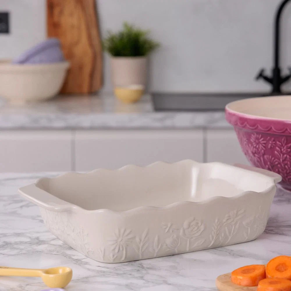 baker with floral design set on a marble counter with other baking tools around it