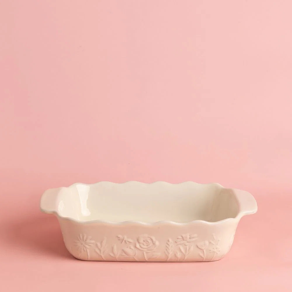 off-white baker with floral design shown on a pink background