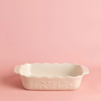 off-white baker with floral design shown on a pink background