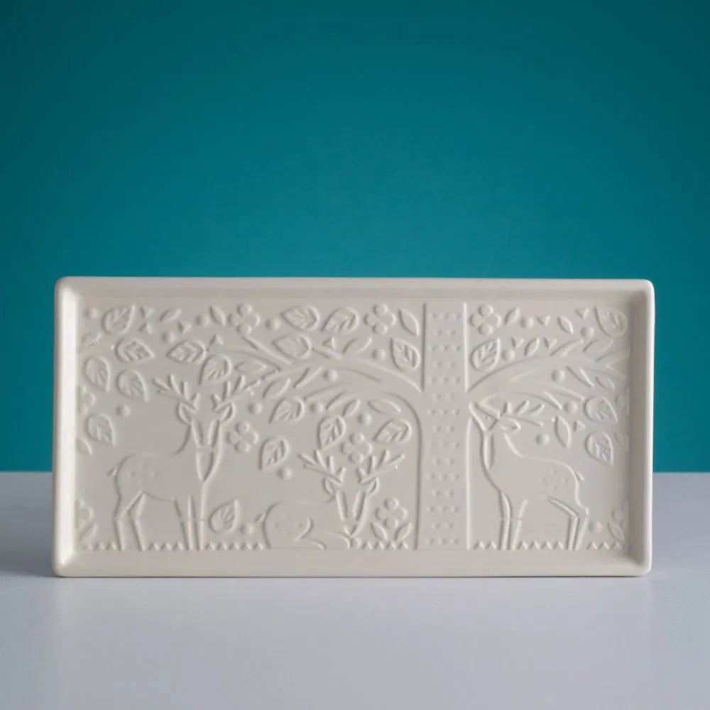 in the forest platter embossed with forest scene shown on a dark teal background