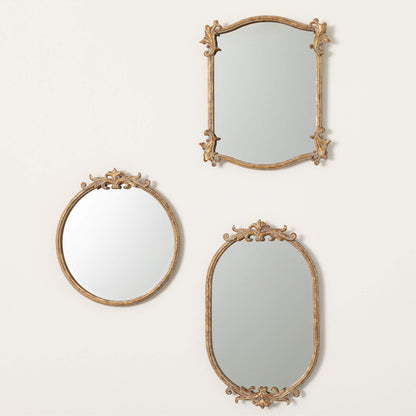 3 styles of gold framed mirrors hung on a white wall.