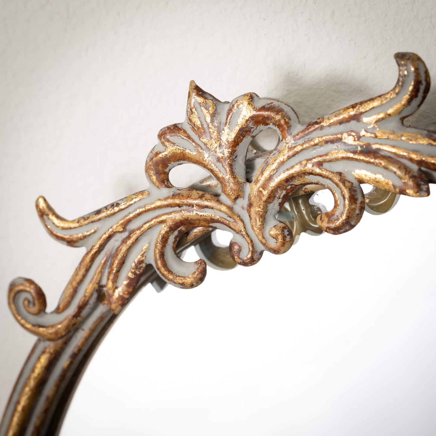 close-up of ornate frame of gold mirror.