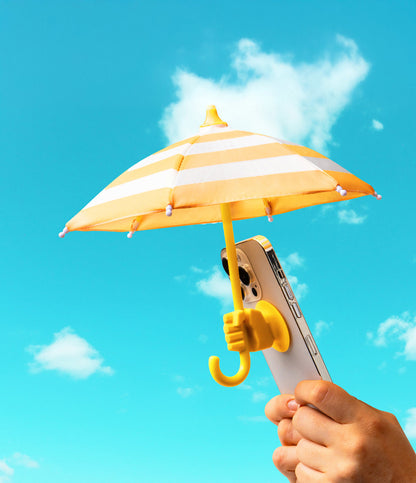 hands holding phone with yellow Cabana Boy Phone Umbrella on a bright sunny day