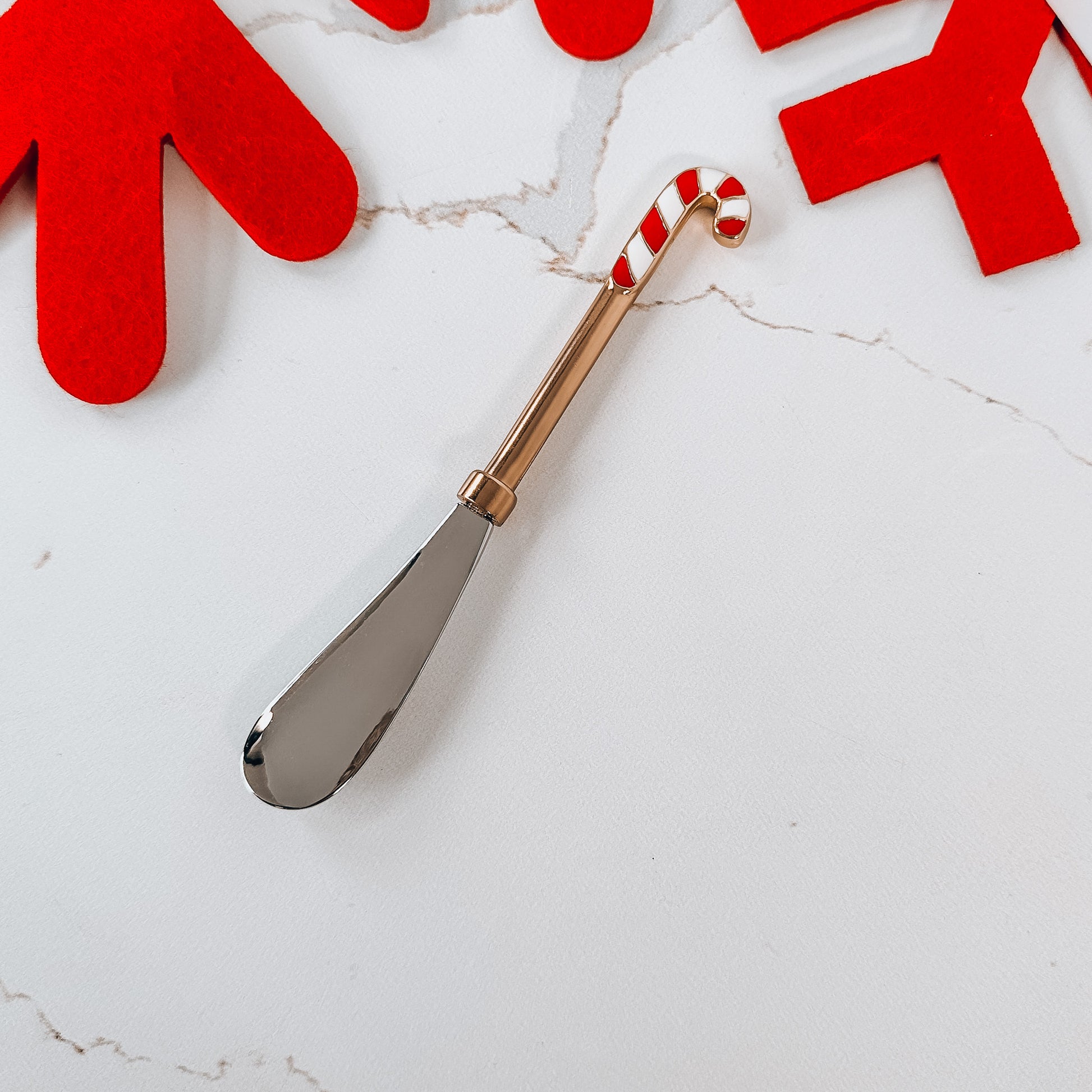 Metal spreader with red and white candy cane handle.