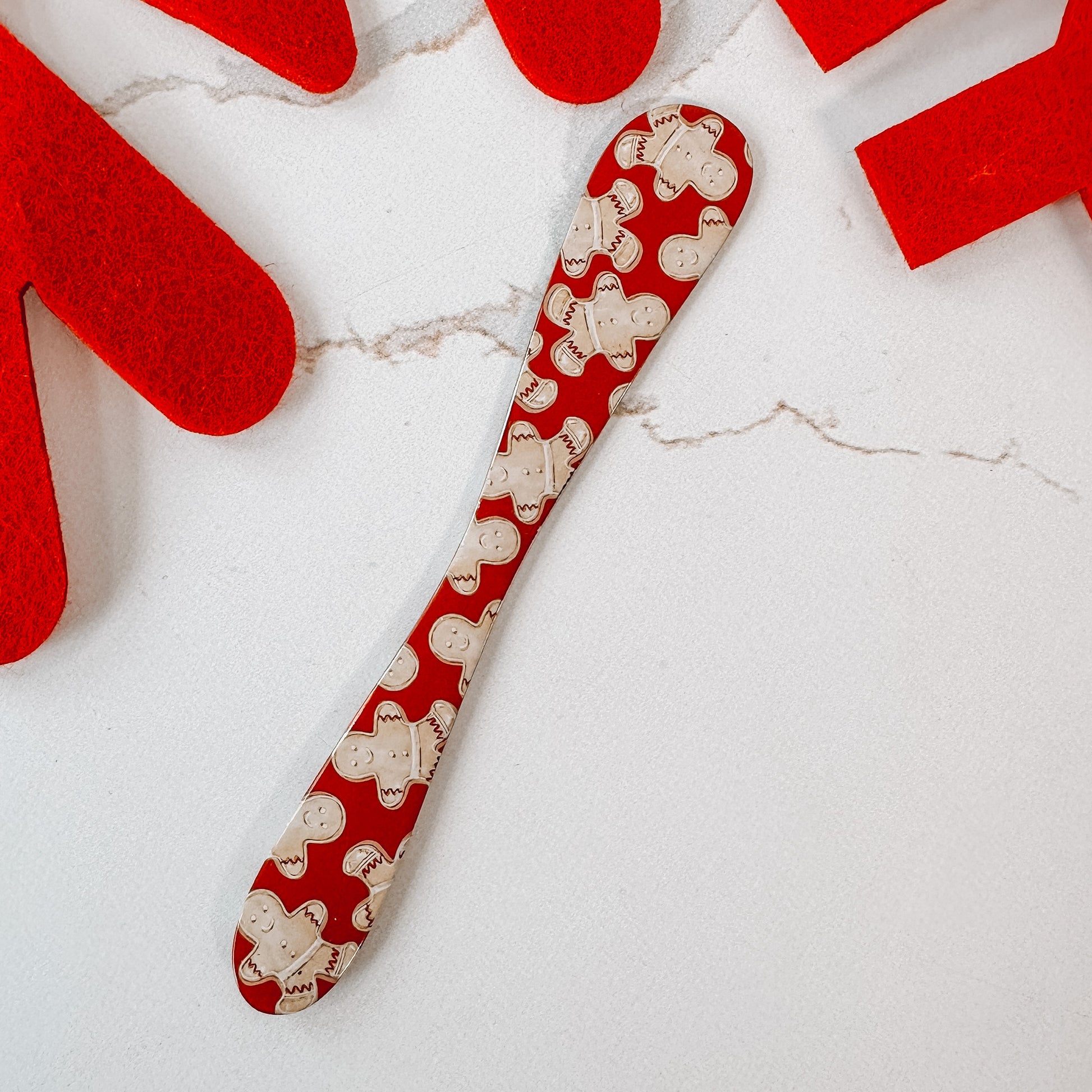 Red metal spreader with gingerbread men all over.