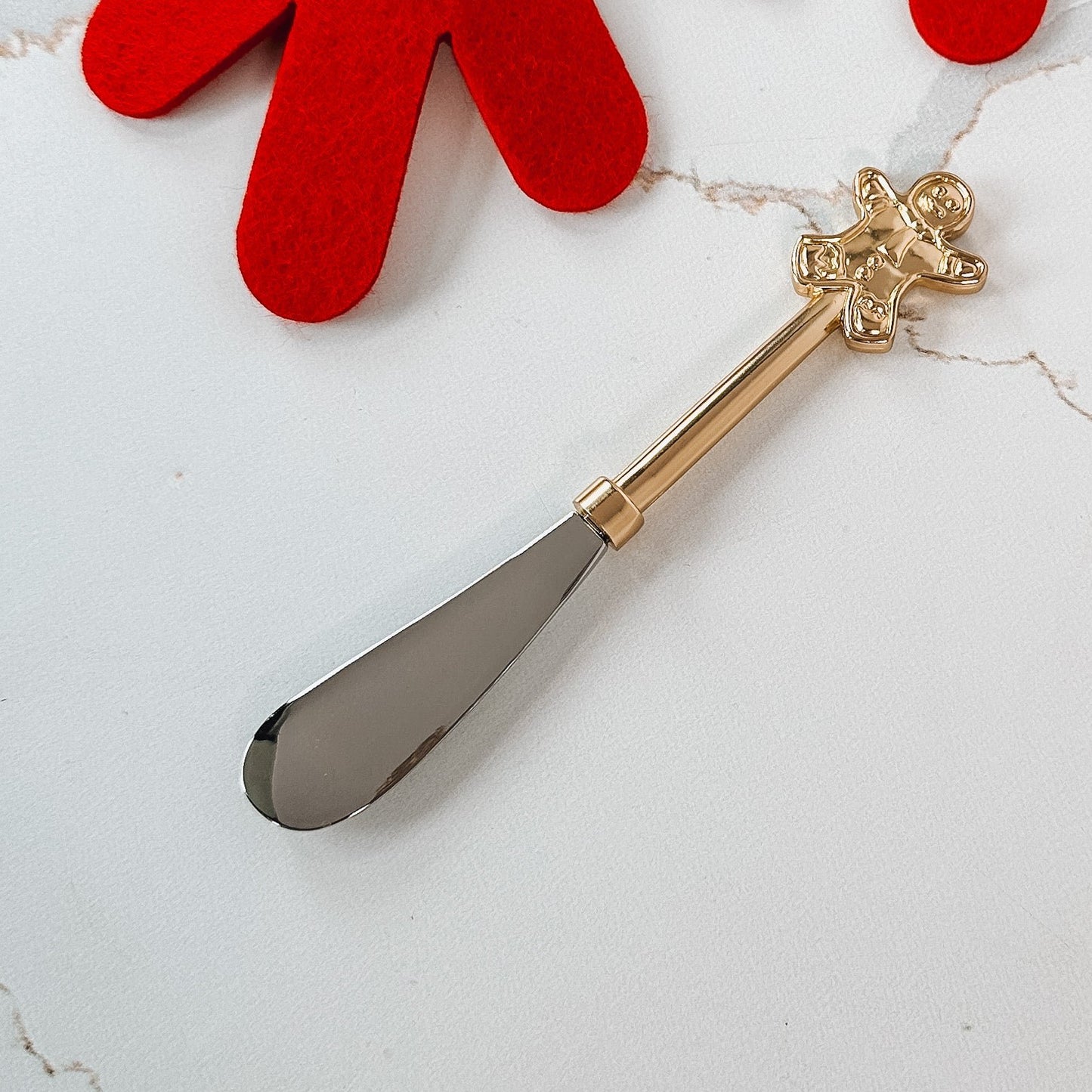 Metal spreader with gingerbread handle.