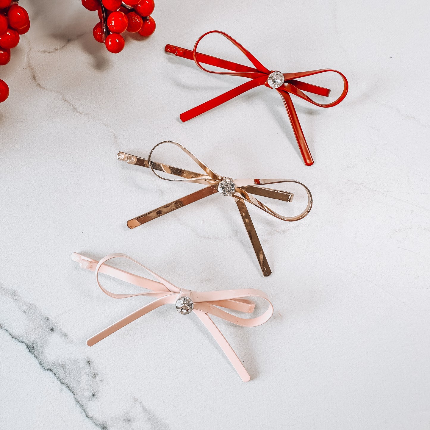 Set of red, gold, and pink ribbon bows with jewel in the middle.