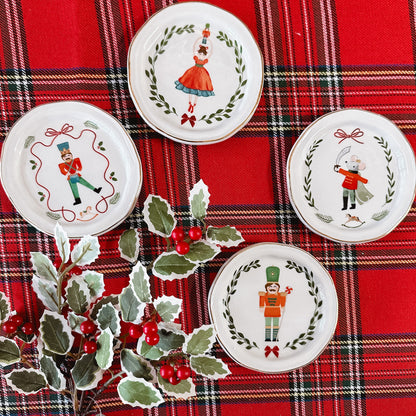 set of four nutcracker tidbit dishes, each with a different design including nutcrackers, a dancer, and a mouse.