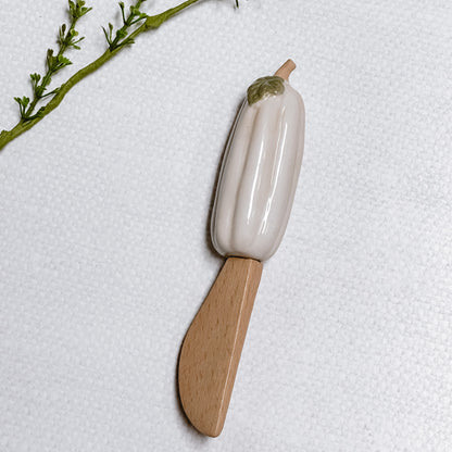 Mud Pie Pumpkin Spreader with white pumpkin on a linen background.