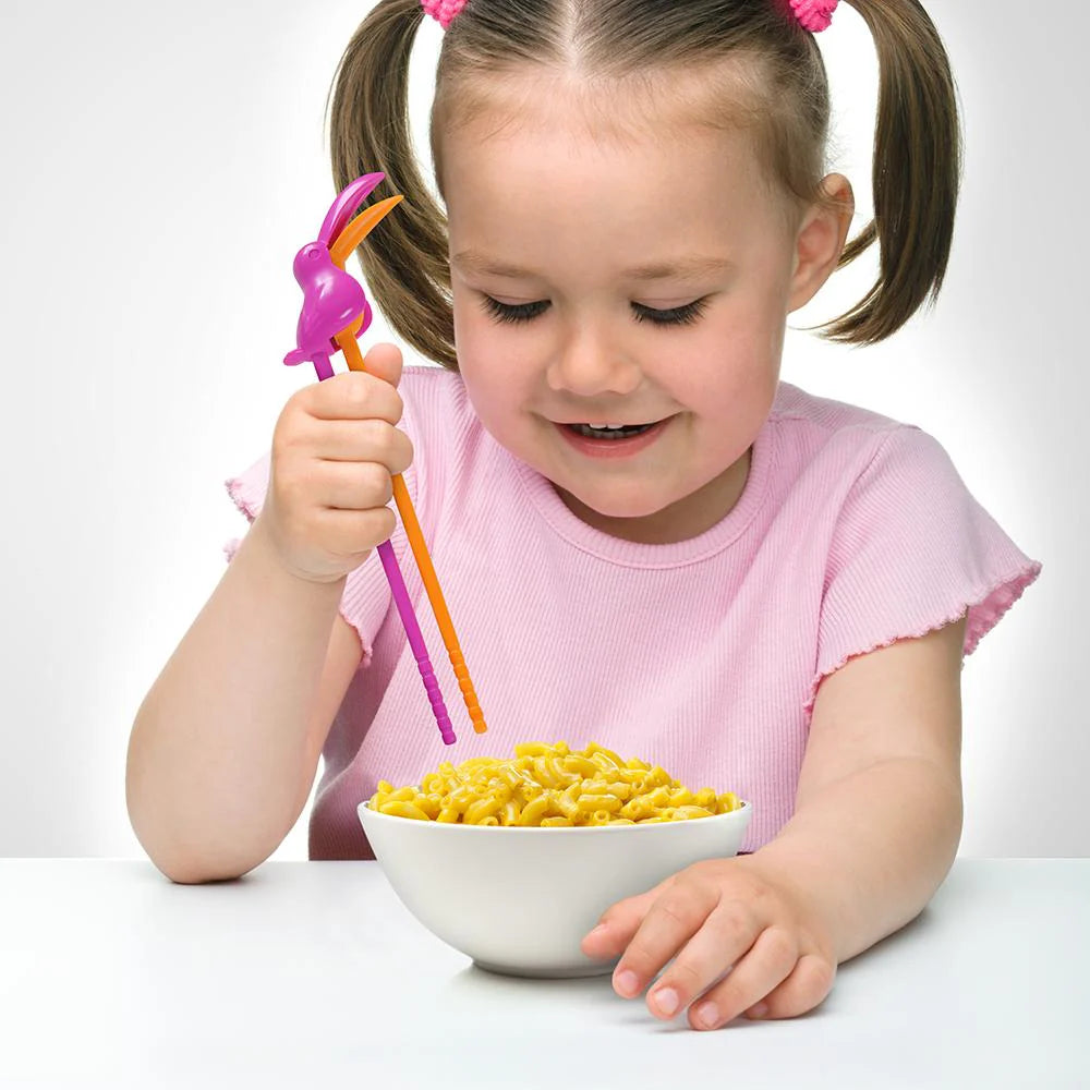 child using toucan chopsticks to eat noddles.