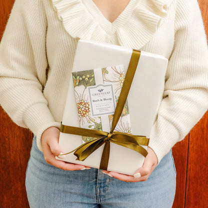 person holding a gift with Birch & Bloom Large Sachet slipped under the ribbon