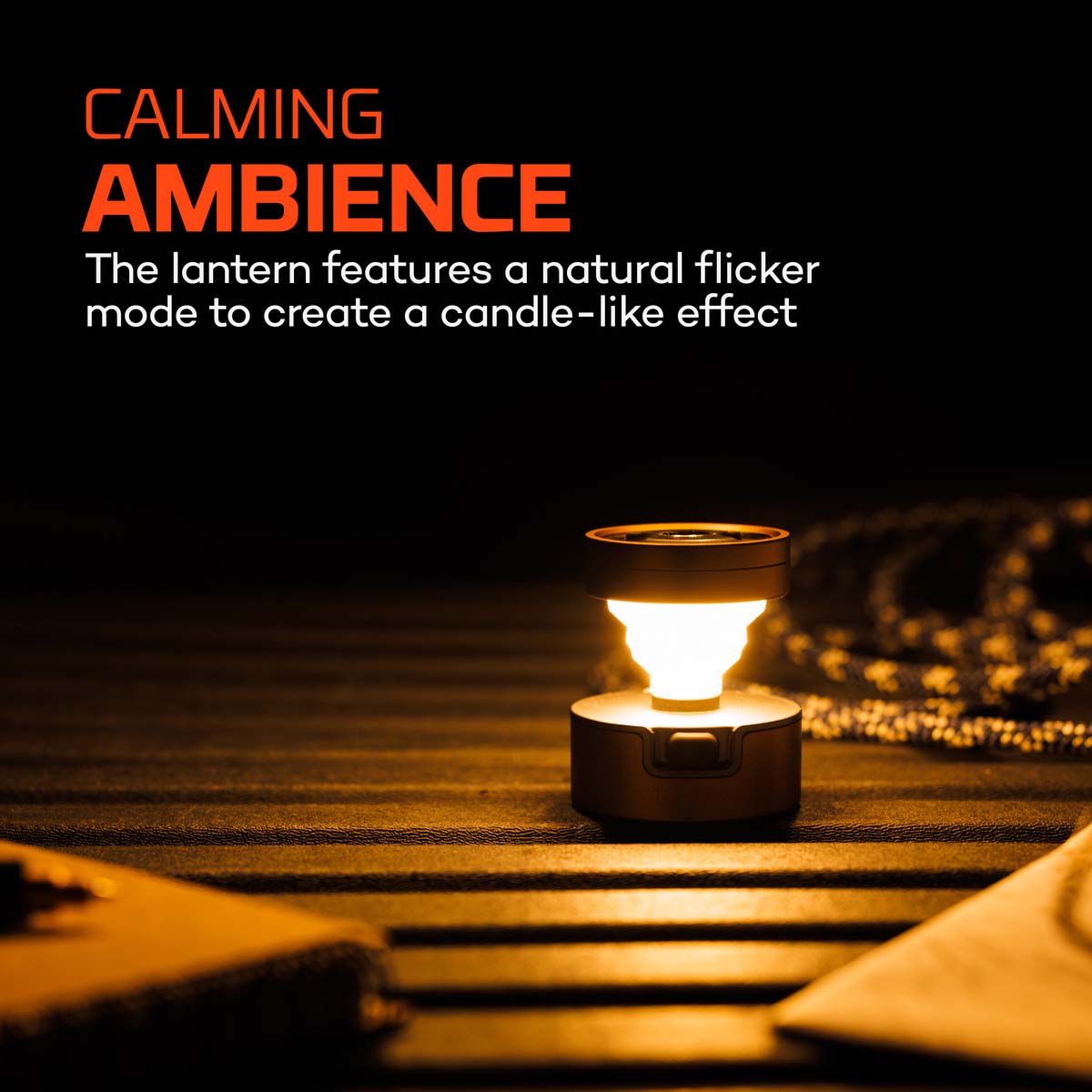 Poppy Puck Pocket Lantern turned on and set on a wooden surface in the dark