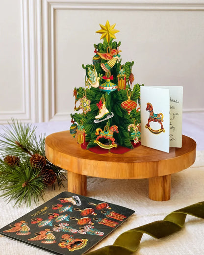 Christmas Tree Mini Pop-Up Card with notecard on a decorated surface
