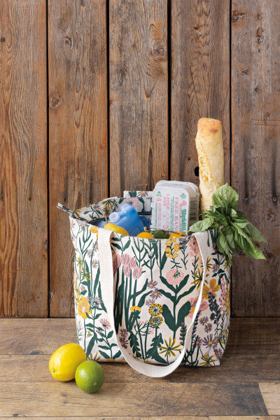 bees and blooms tote filled with groceries and set on a wooden table.