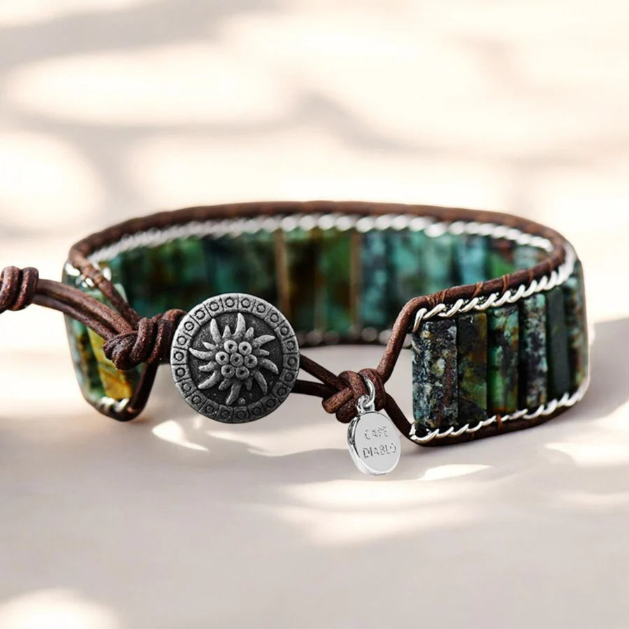 Bracelet with green stone and button clasp on a light background