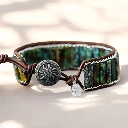 Bracelet with green stone and button clasp on a light background