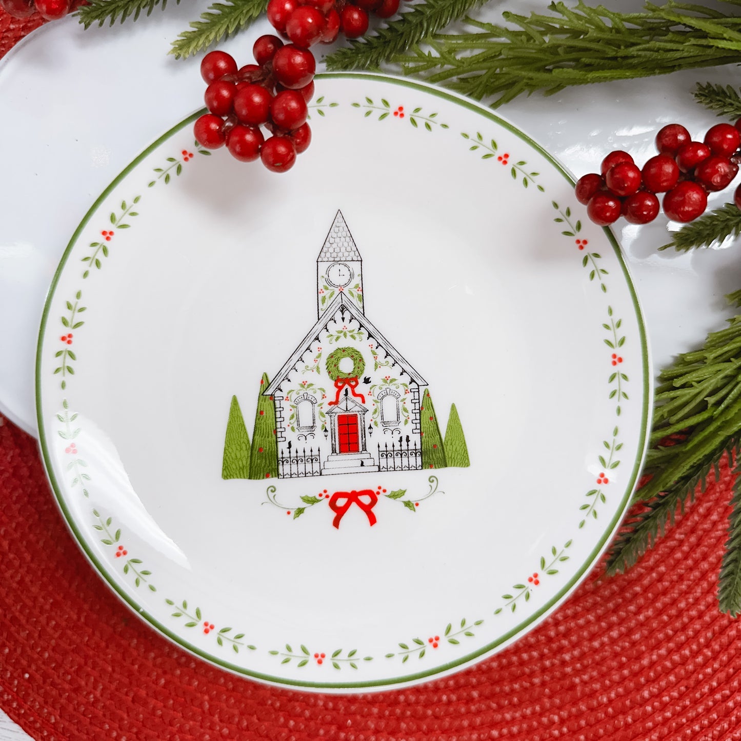 White ceramic plate decorated with line drawn church in black, white, and green.