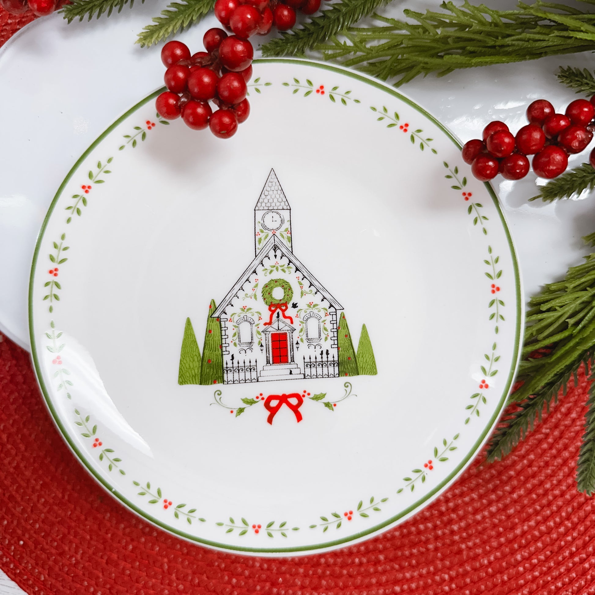 White ceramic plate decorated with line drawn church in black, white, and green.