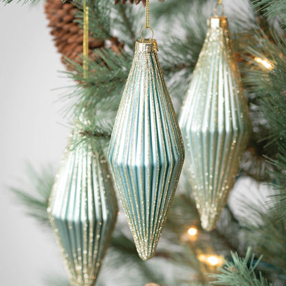 close up view of three drop ornaments hanging on a tree