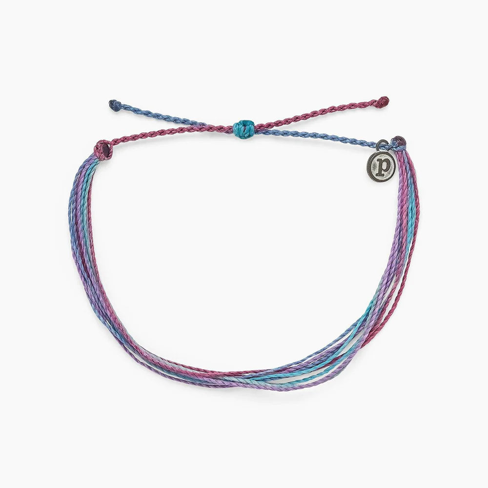 Pura Vida multi strand corded bracelet in varying shades of blues and purples with a Pura Vida logo charm