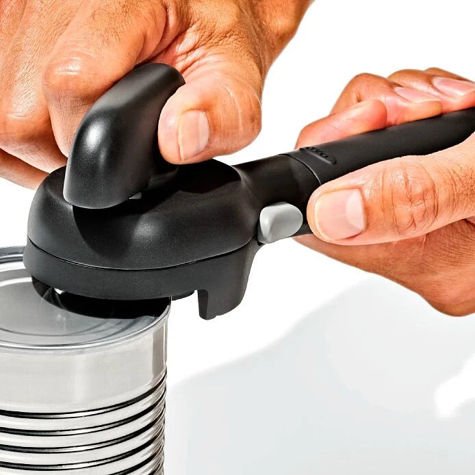close-up of hands holding Smooth Edge Can Opener on a can