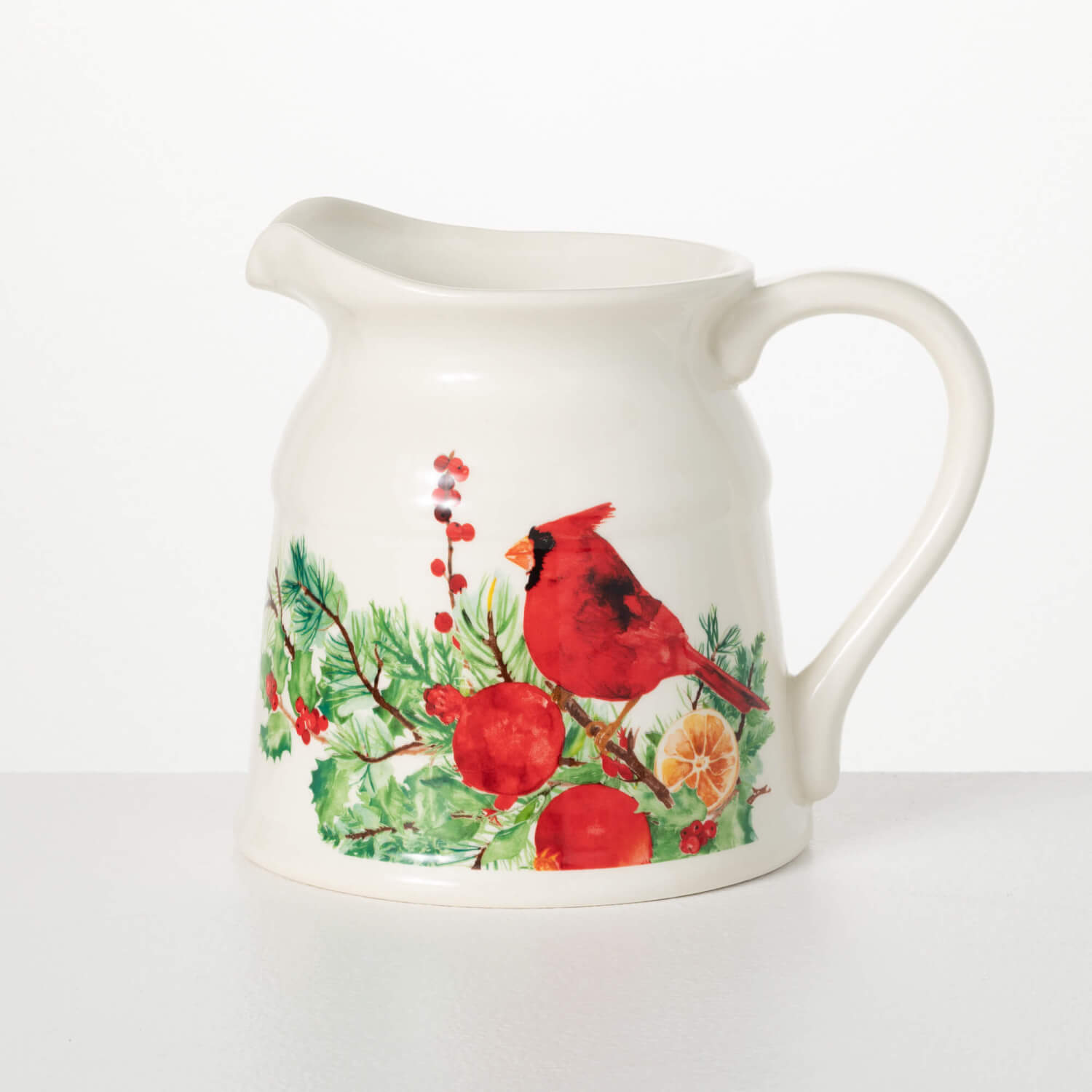 creamy white pitcher with cardinal and evergreen art work painted on it.