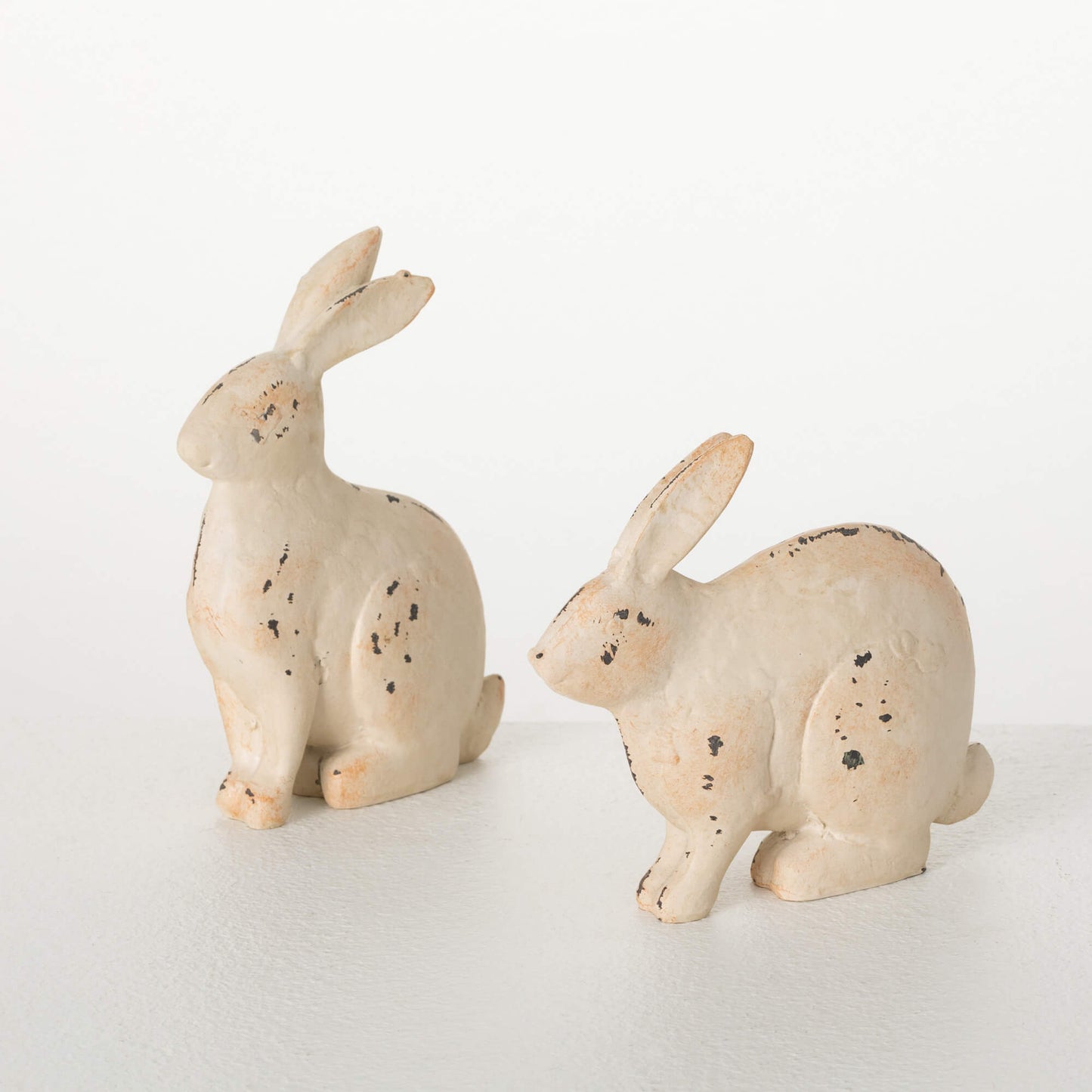 2 styles of Metal Bunny Figurines on a white background.