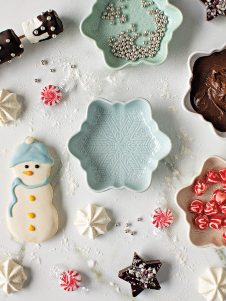 top view of table arranged with snowflake bowls, candies, and cookies.