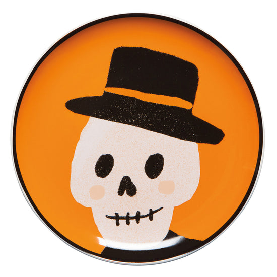 plate with skull wearing top hat on orange background