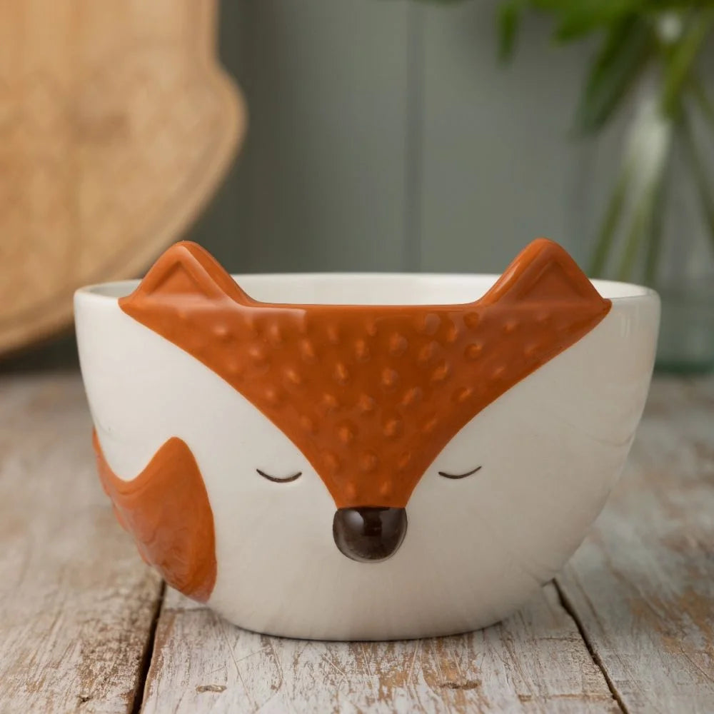 off-white and orange bowl with fox design set on a wooden table.