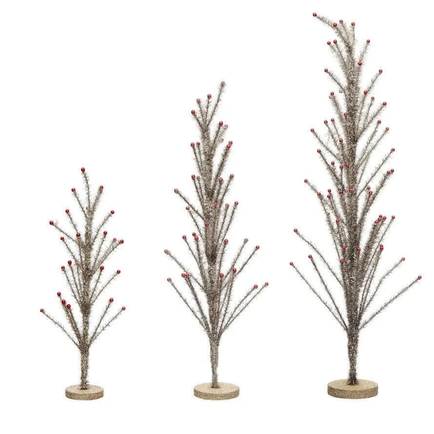 3 sizes of silver tinsel trees in a row with their branches folded up.