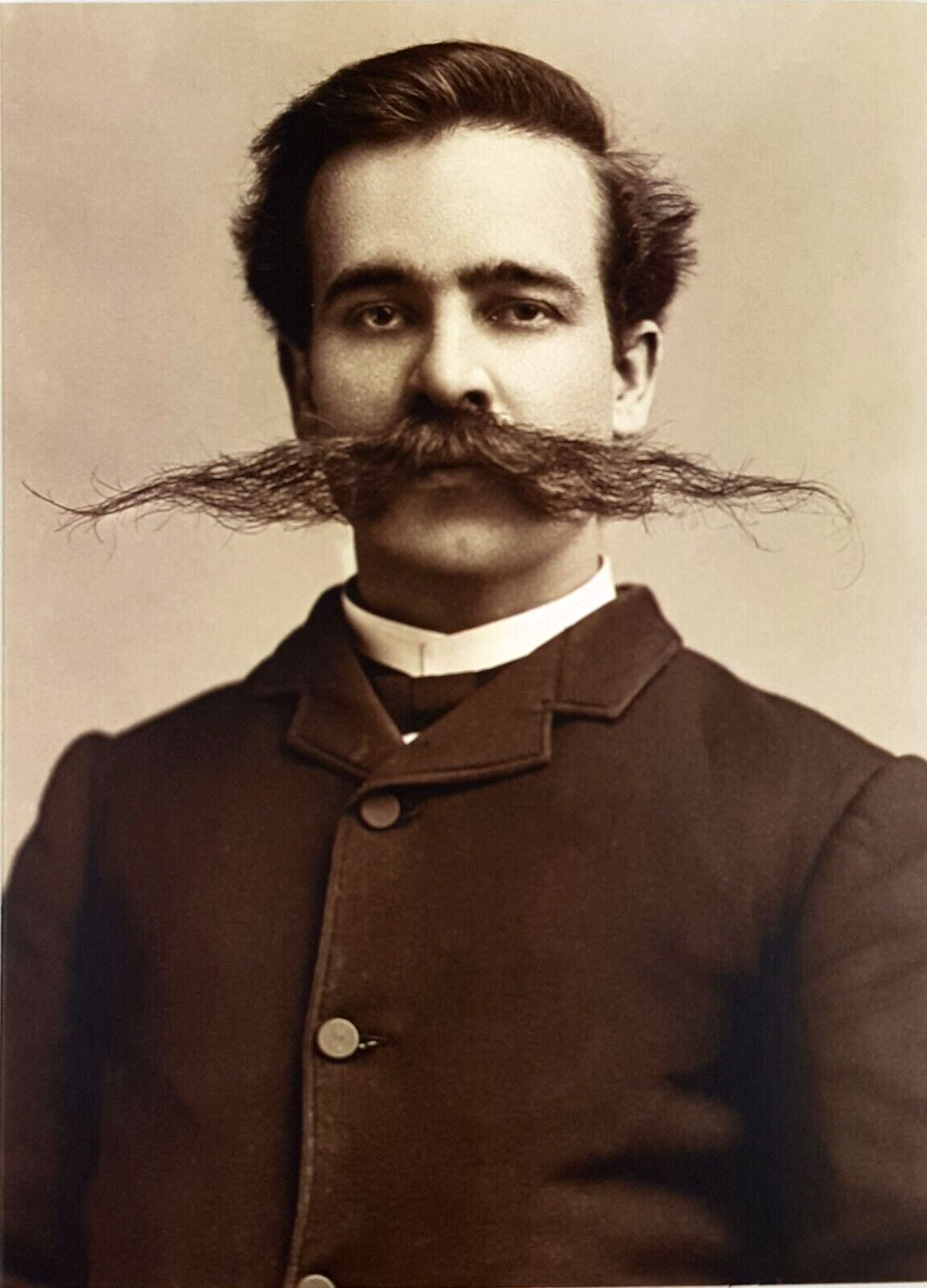 front of card is old-timey photo of man with mustache sticking straight out on both sides 