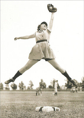 front of card is a female softball player jumping up to catch a ball with her team in the background in black and white