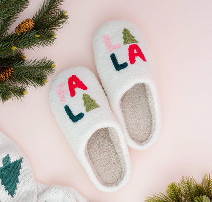 fa la la fuzzy slippers on a light pink background with sprigs of greenery.