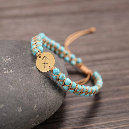 Sagittarius bracelet draped on a stone on a wooden table.