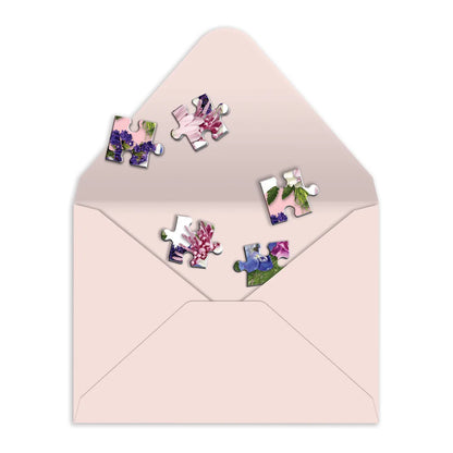 light pink envelope with puzzle pieces in it.