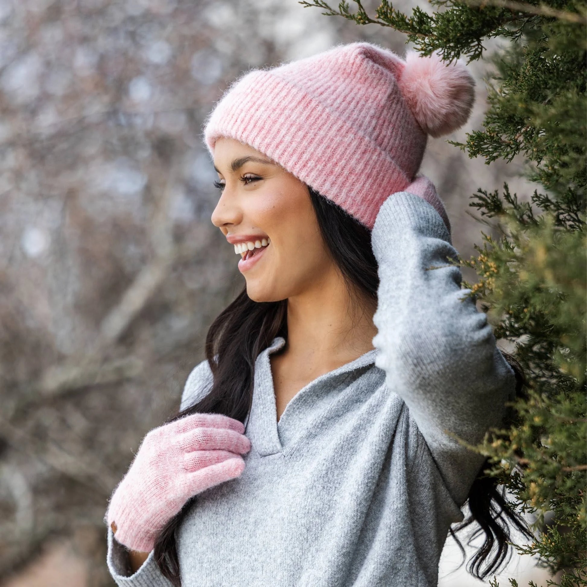 person wearing a pink knit beanie and gloves outdoors