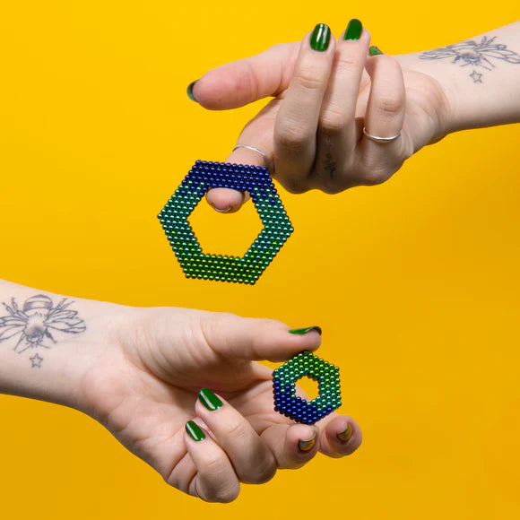 hands holding shapes made from gradient soothe magnetic balls