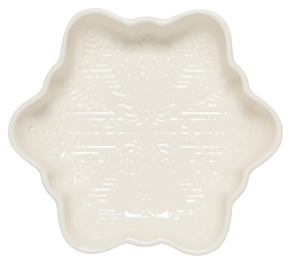 cream colored ceramic dish shaped like a snowflake with a snowflake design on the interior.