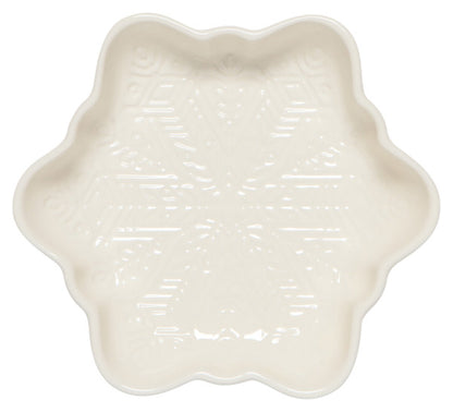 cream colored ceramic dish shaped like a snowflake with a snowflake design on the interior.