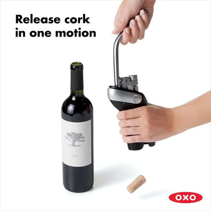 hand holding Vertical Lever Corkscrew and releasing pulled cork