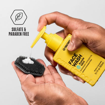 hands pumping face wash onto a scrubber.