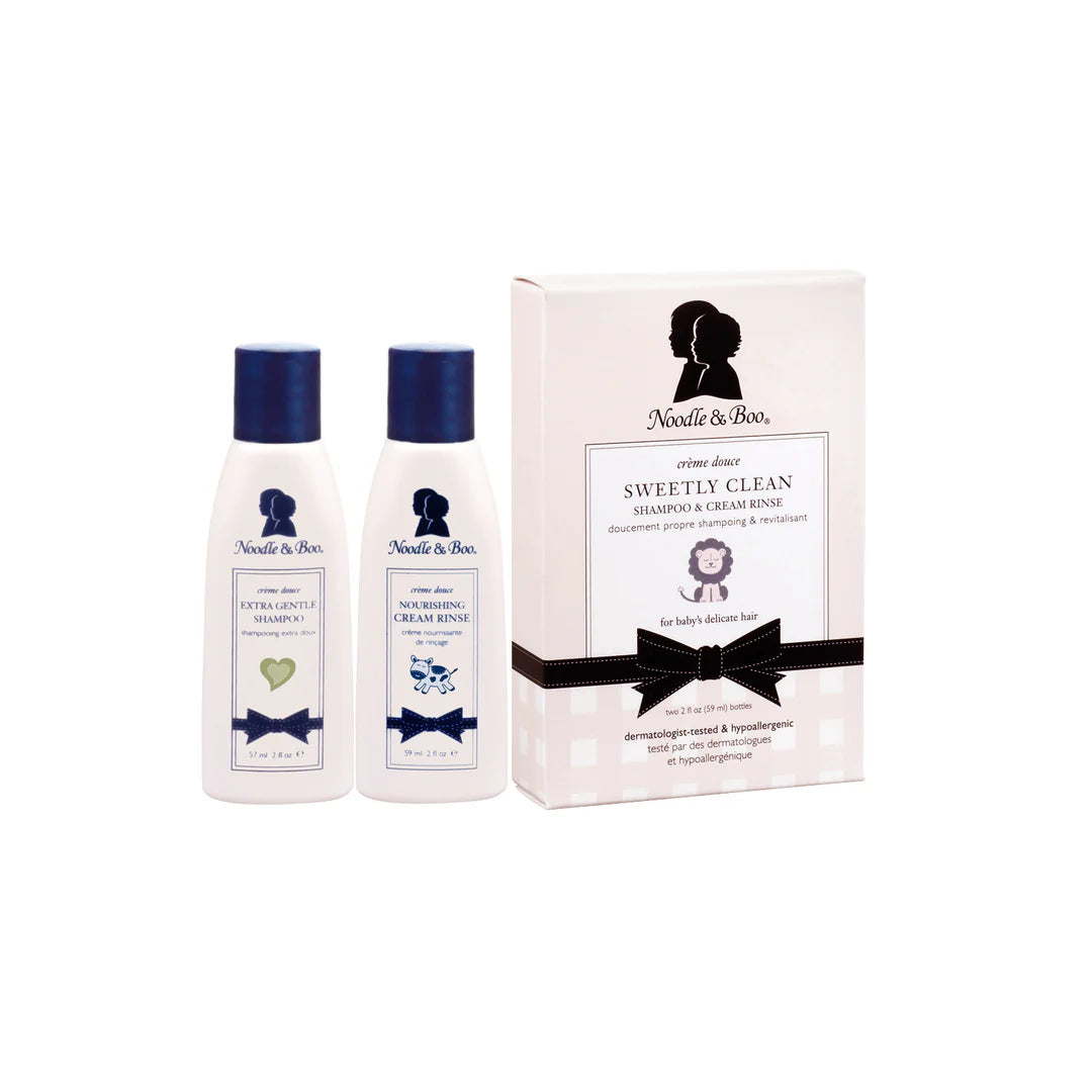 Two bottles of Noodle & Boo baby wash set next to their box packaging on a white background