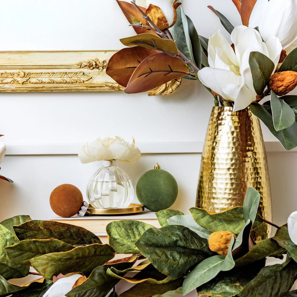 Birch & Bloom Flower Diffuser set on a side table with greenery and a hammered brass vase