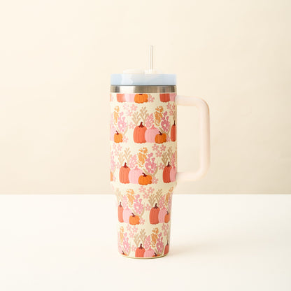 Cream colored tumbler with pink and orange foliage and pumpkins.