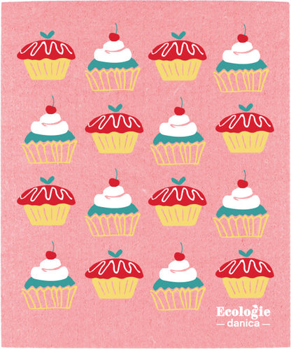 cake walk Swedish Sponge Dishcloth has a pink background with a variety of cupcake artwork printed on it.