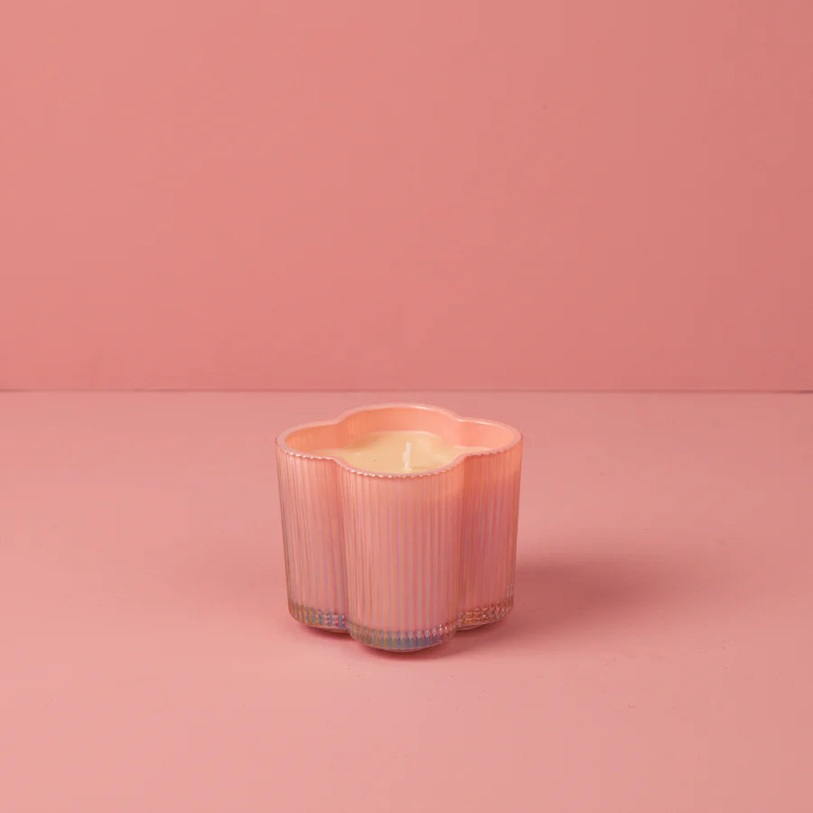 Pink ribbed glass candle on a pink background